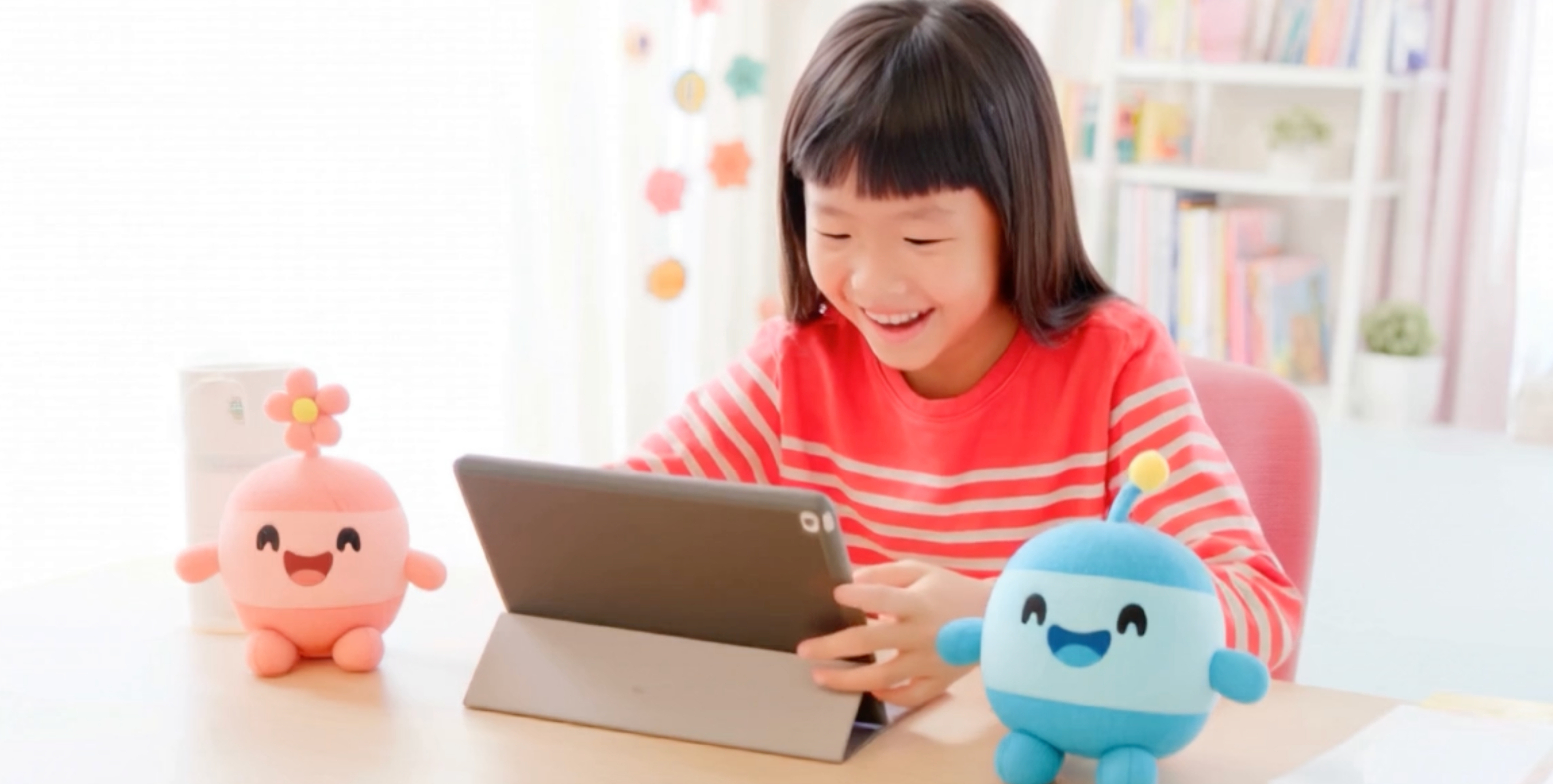 Girl on tablet with LittleBots plushies